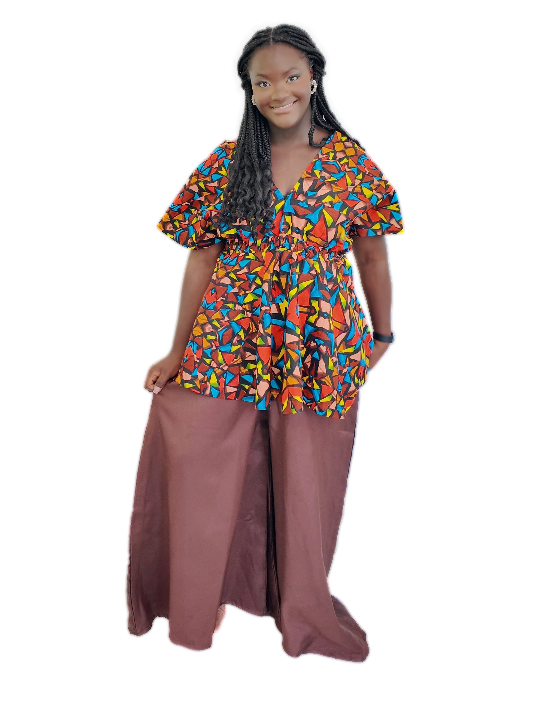 Woman wearing a colorful patterned top and brown pants on a white background